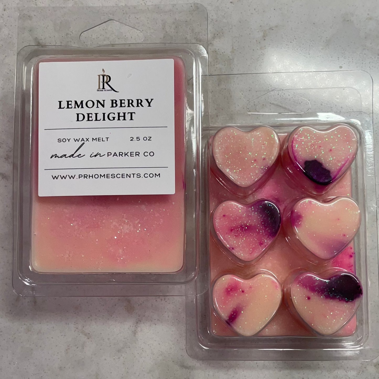 Close-up of heart-shaped soy wax melt in marbled purple with opulent glitter. Infused with the refreshing scent of lemon and mixed berries, creating a delightful aromatic experience. Perfect for elevating your space with a touch of citrusy sweetness and vibrant allure.