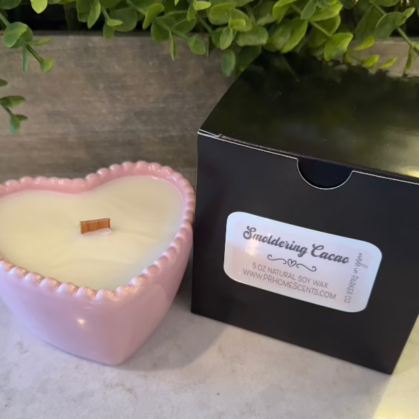 Smoldering Cacao soy wax candle in a pink heart-shaped reusable bowl with gingered vanilla and smoked cacao fragrance. 35-hour burn time.