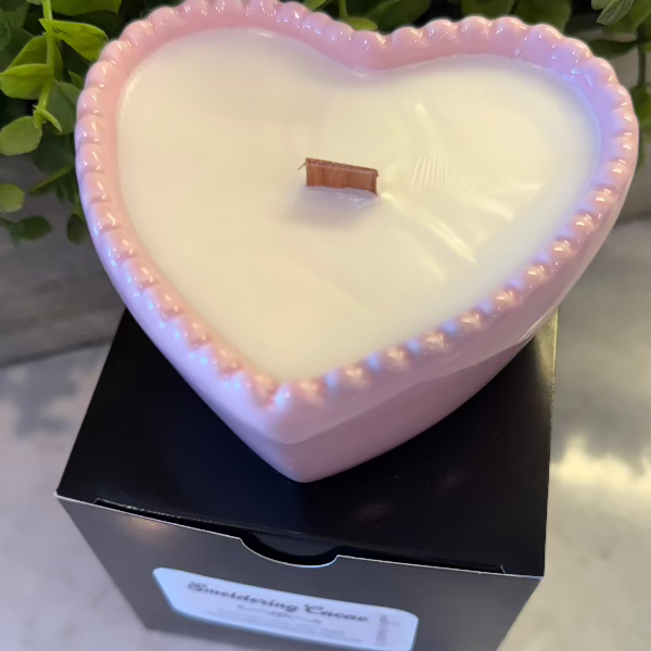 Smoldering Cacao soy wax candle in a pink heart-shaped reusable bowl with gingered vanilla and smoked cacao fragrance. 35-hour burn time.