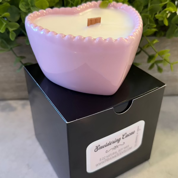 Smoldering Cacao soy wax candle in a pink heart-shaped reusable bowl with gingered vanilla and smoked cacao fragrance. 35-hour burn time.