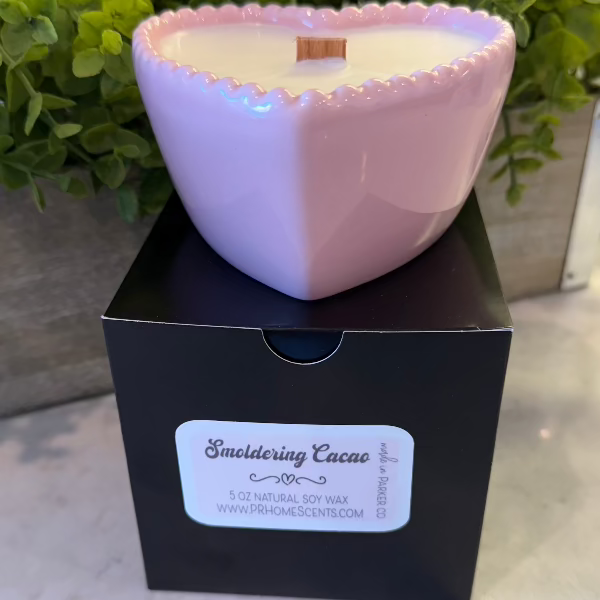 Smoldering Cacao soy wax candle in a pink heart-shaped reusable bowl with gingered vanilla and smoked cacao fragrance. 35-hour burn time.